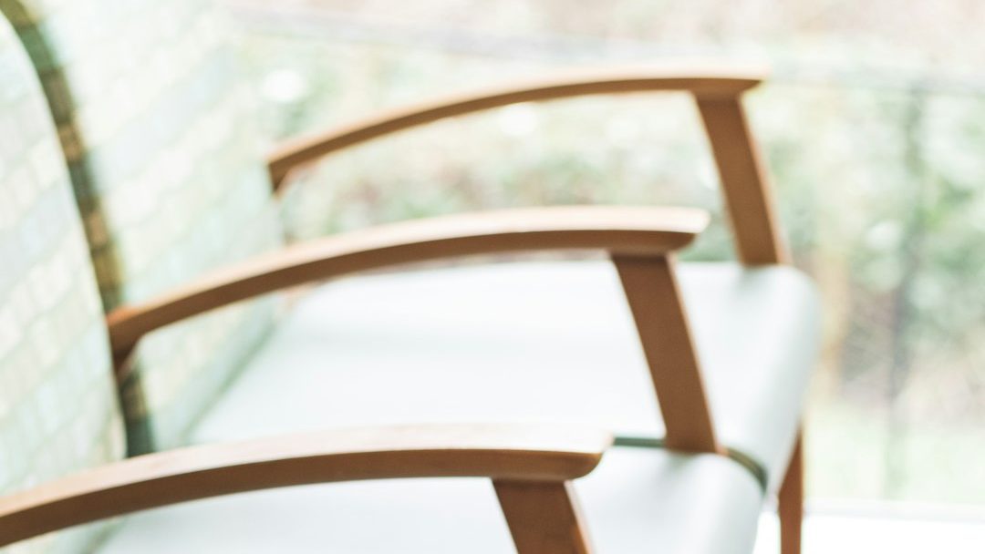 brown wooden framed white padded armchairs